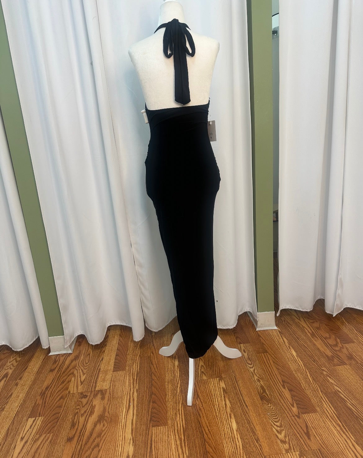 black stretch material dress, halter top, gold design on hip.